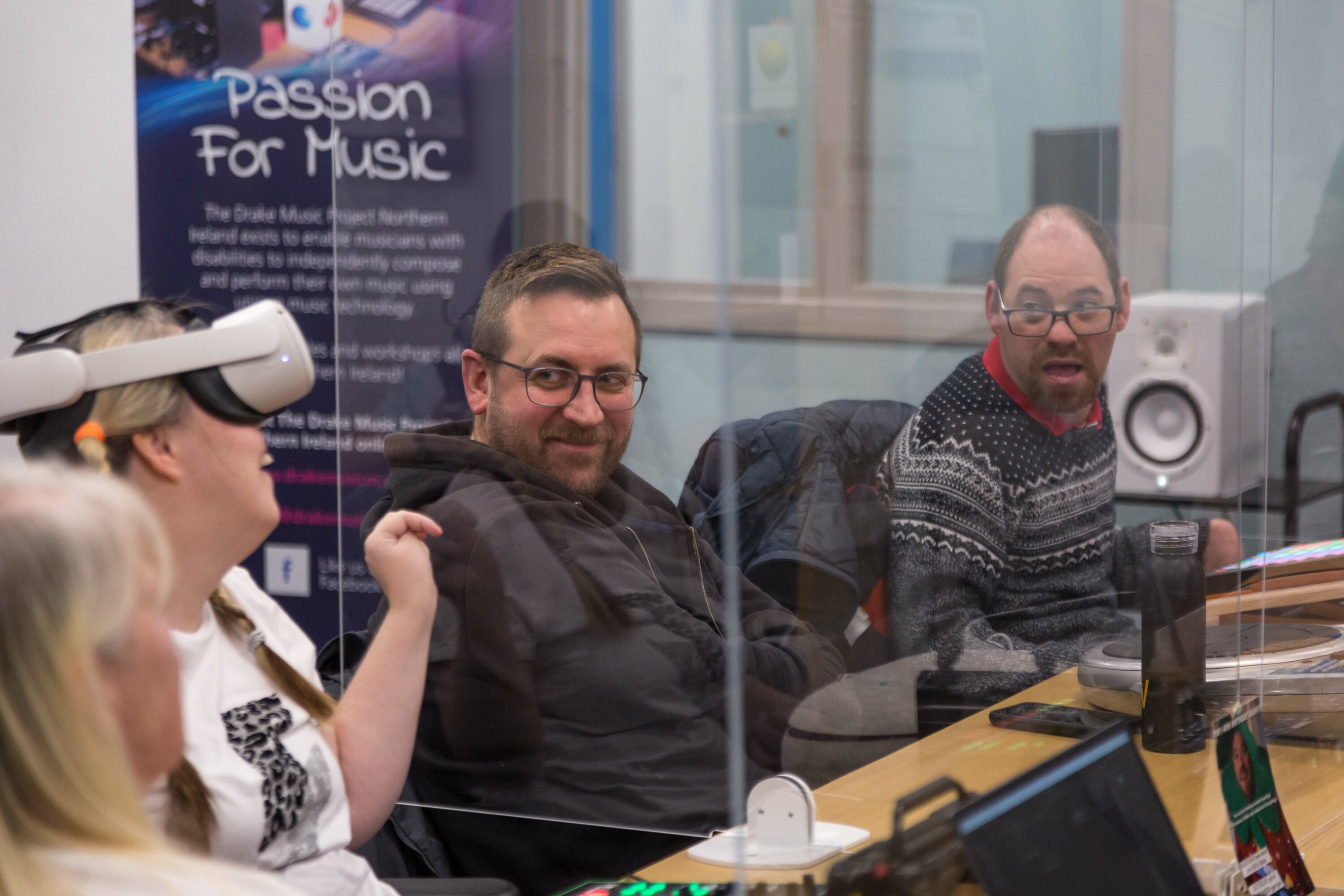 Musician Marylouise, wearing a VR headset interects with other two participants in the room, Tim and Chirs, at Drake's studio in Belfast.